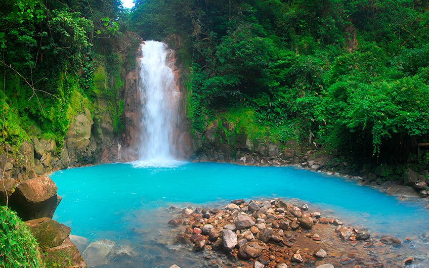 The powerful waterfall and the natural pool of turquoise water are surrounded by the greenery of the landscape and offer an unbeatable view of the Tenorio Volcano National Park, in Guanacaste.